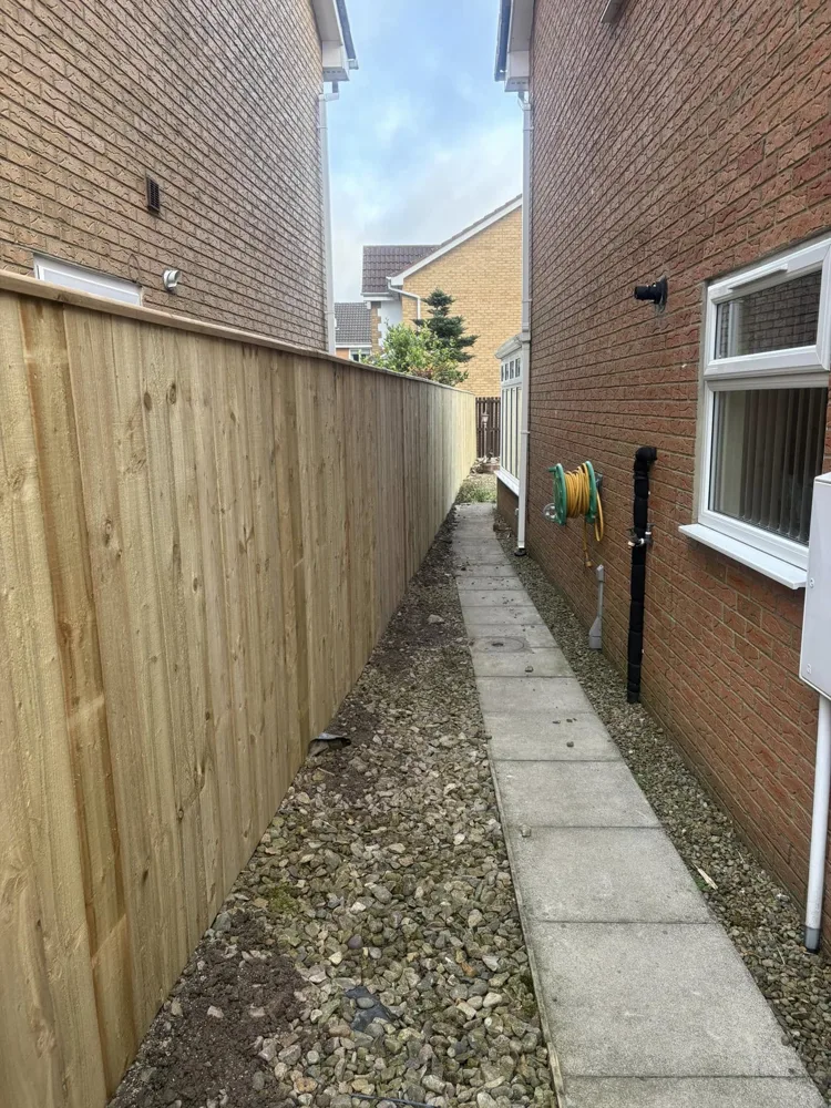 Newly built timber fence along a narrow side passage